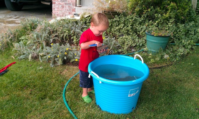 Sweet boy scrubbing rocks - his dad makes that same face